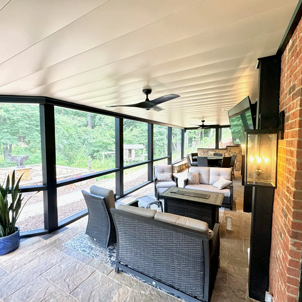 Screened patio lounge with ceiling fan and wicker seating