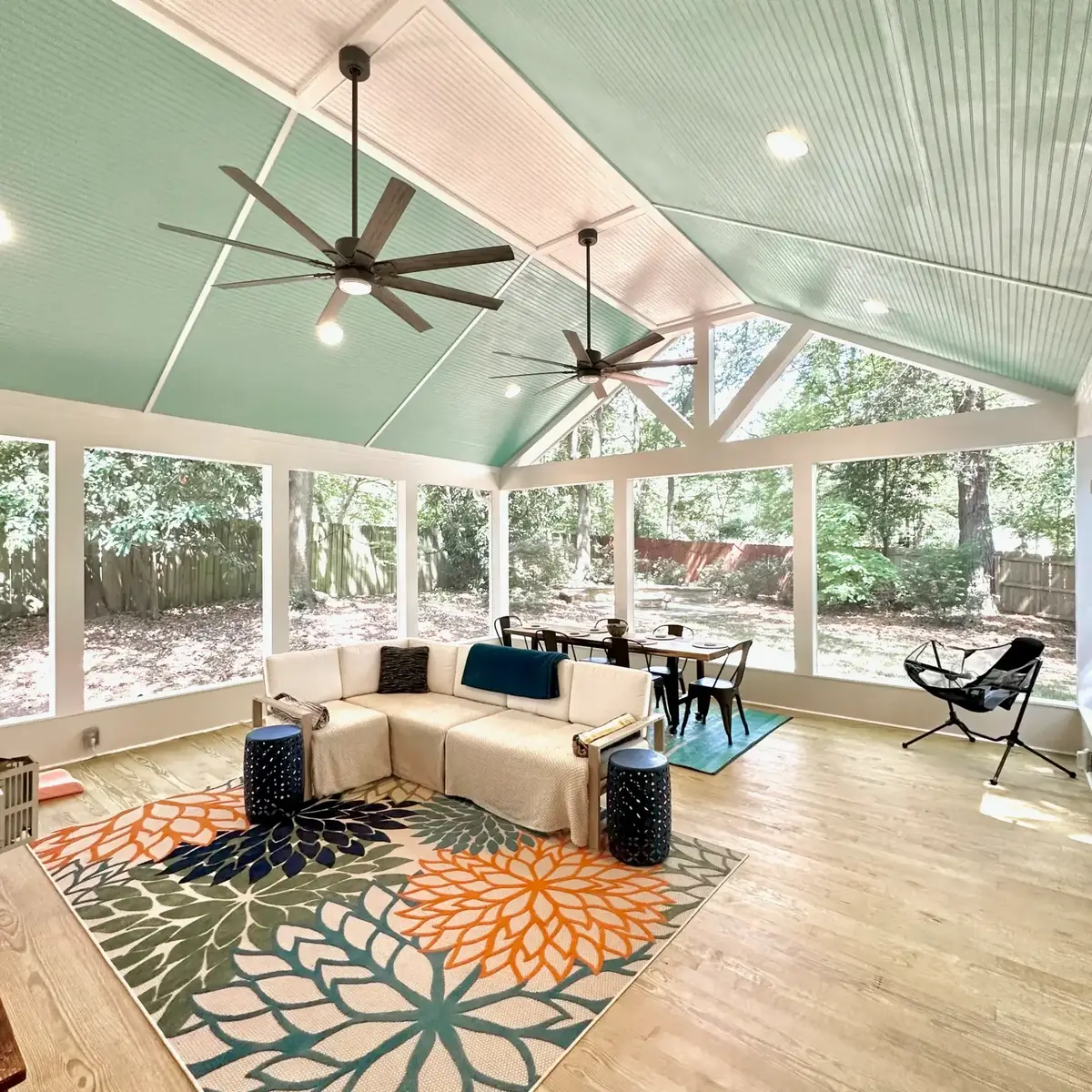 Seating corner of the Atlanta screen room with sectional sofa and gable windows