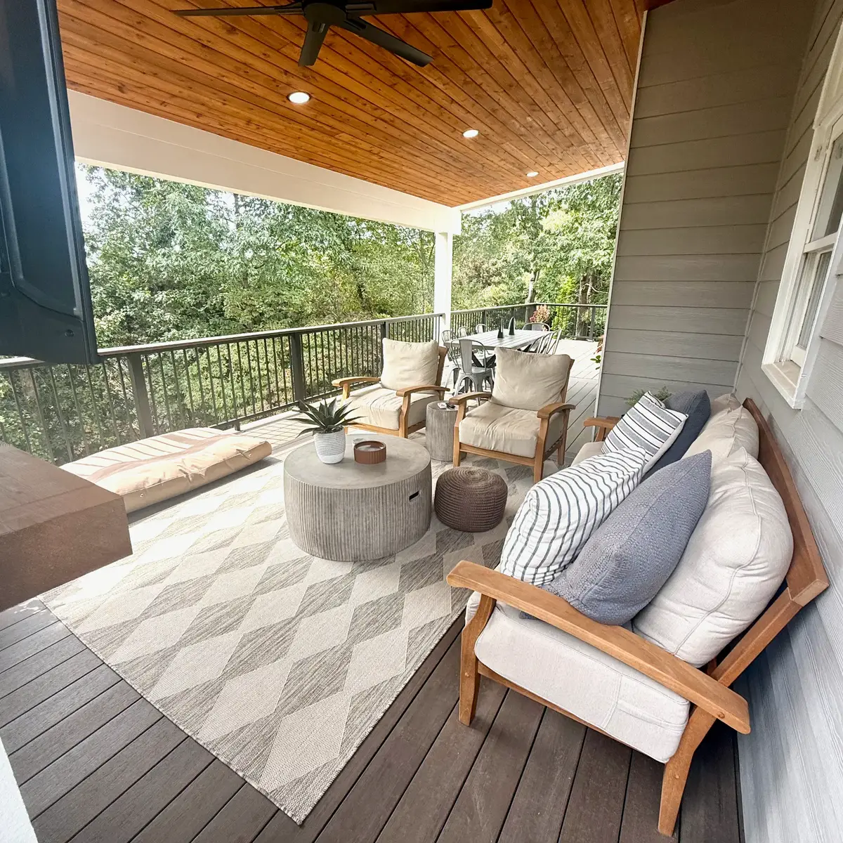 Seating and dining areas on the Smyrna covered porch with American Walnut PVC decking