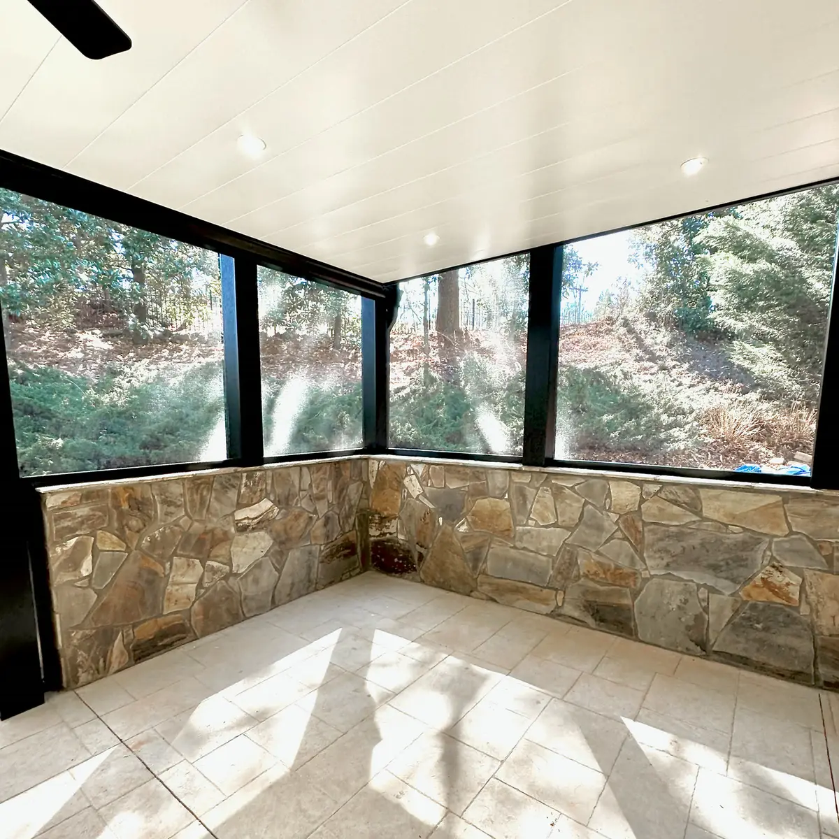 Screened patio with stacked stone knee wall