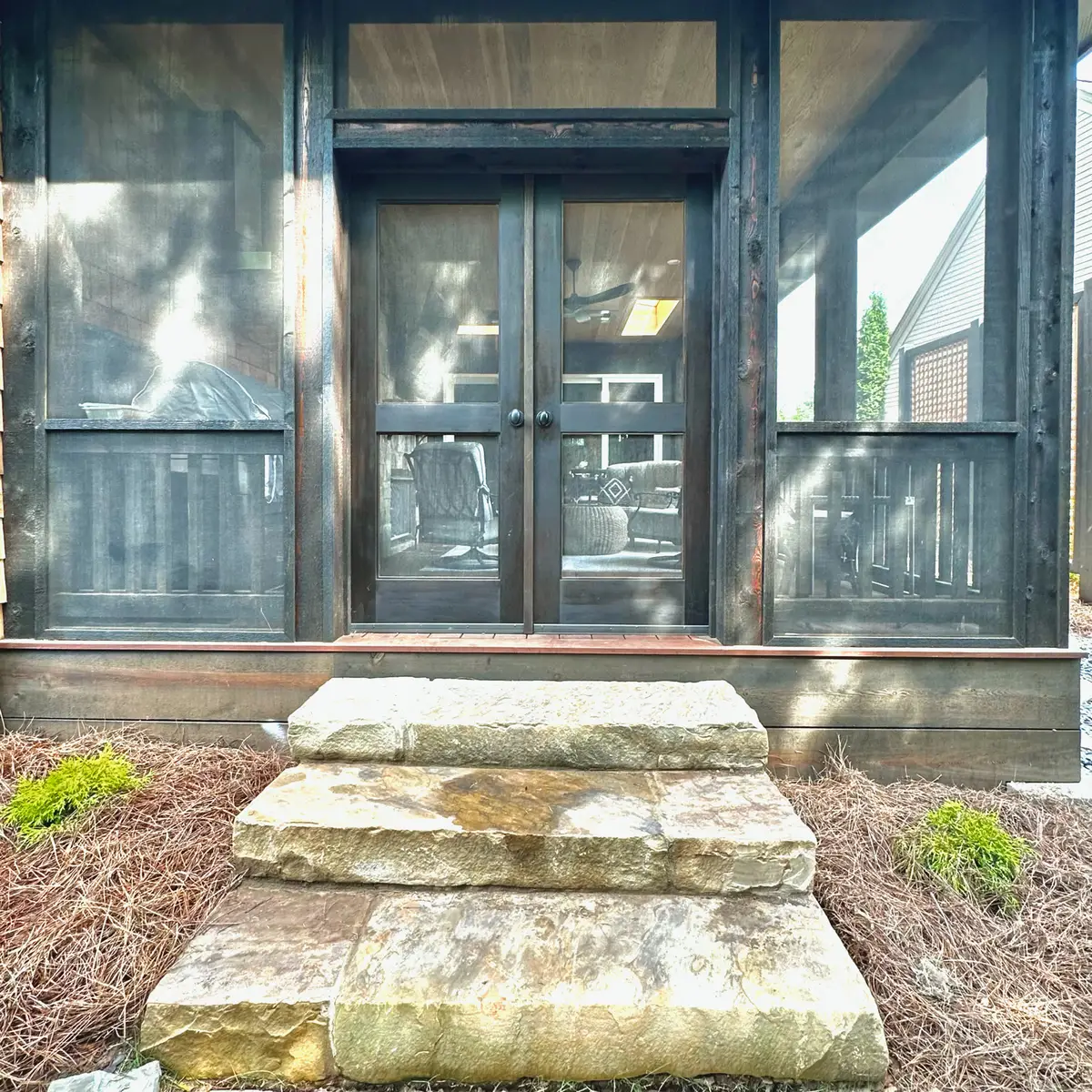 Screened porch double doors with natural stone steps