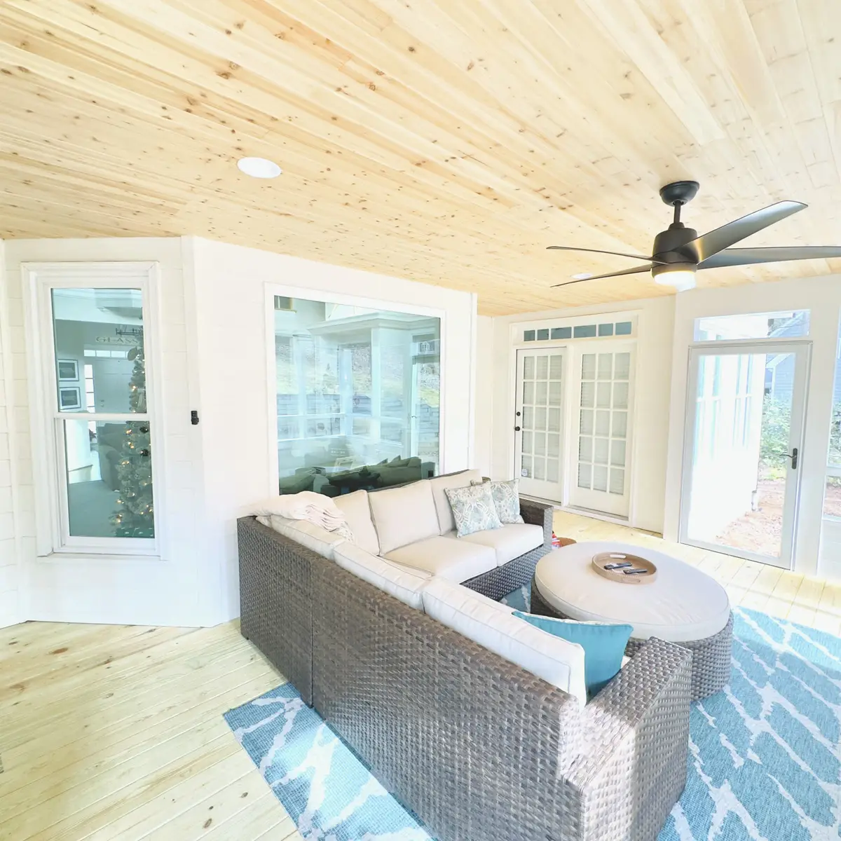Sunroom seating area with pine ceiling and ceiling fan