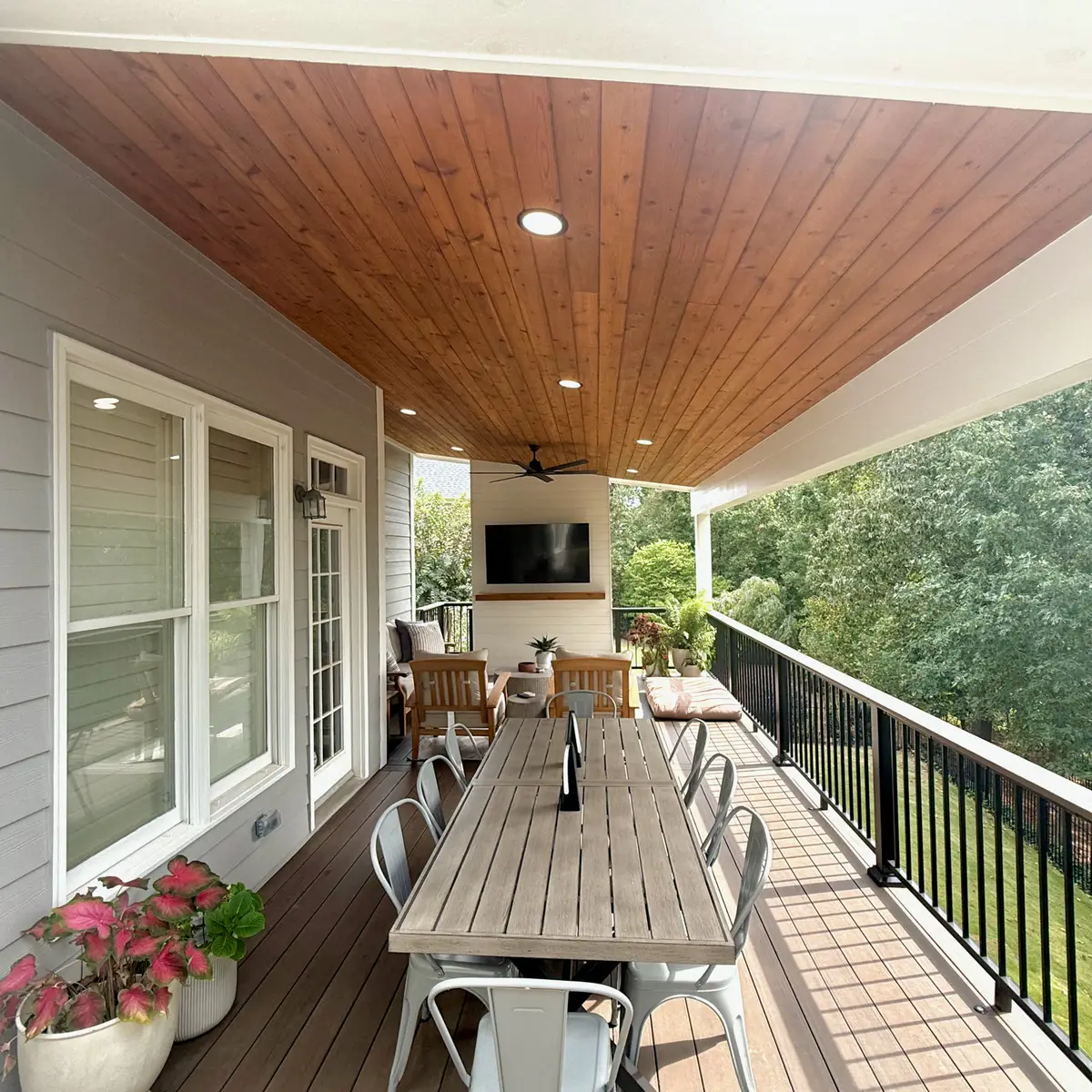 Covered deck with cedar ceiling, outdoor TV and long dining table