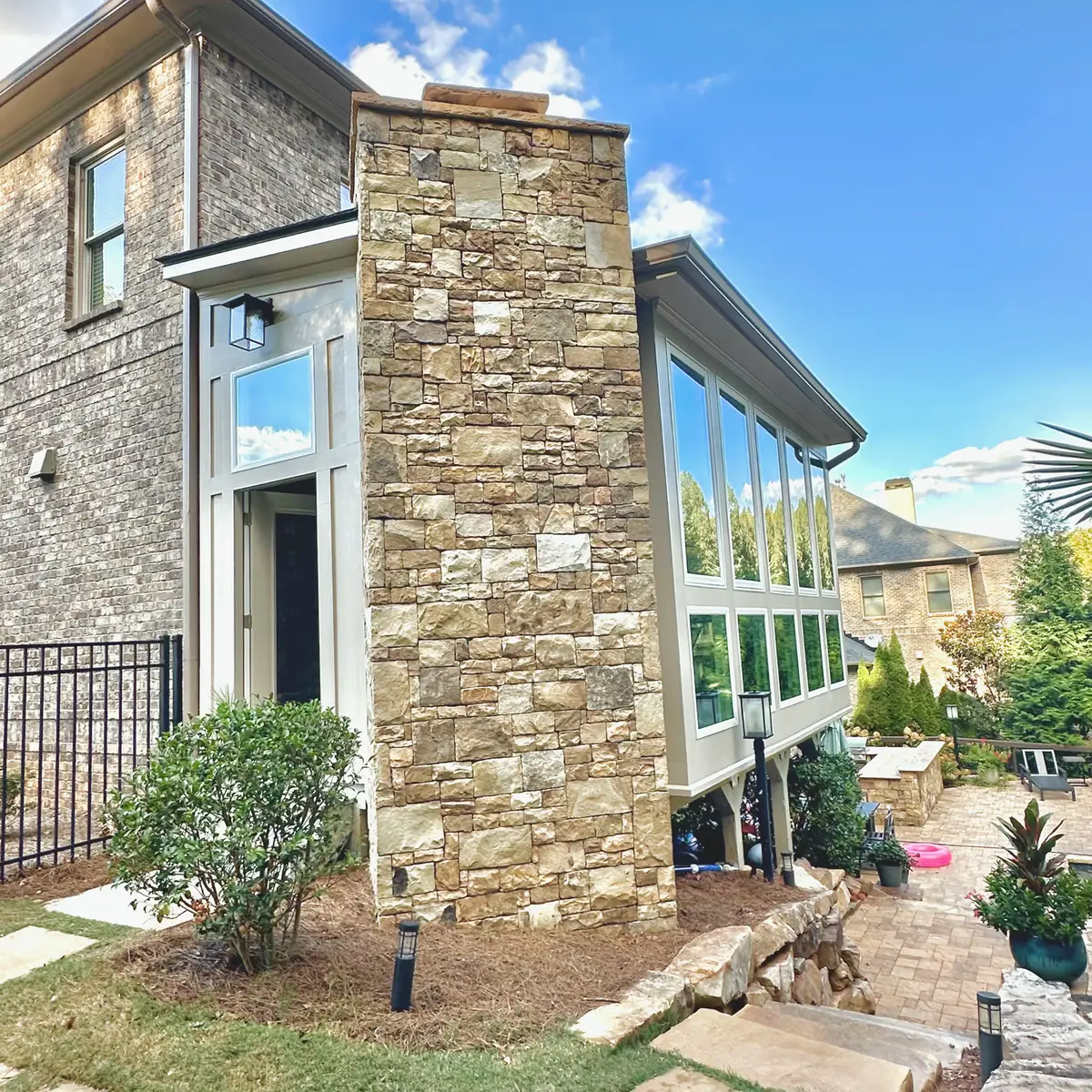 Sunroom addition with stacked stone chimney