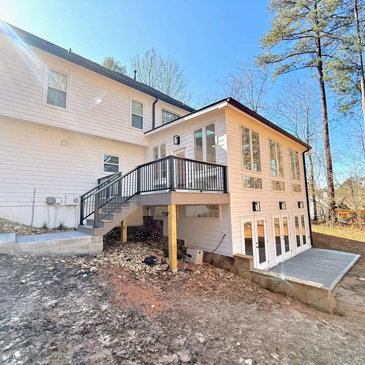 Fayetteville two-story addition with sunroom above, basement extension below and PVC deck with black aluminum railing
