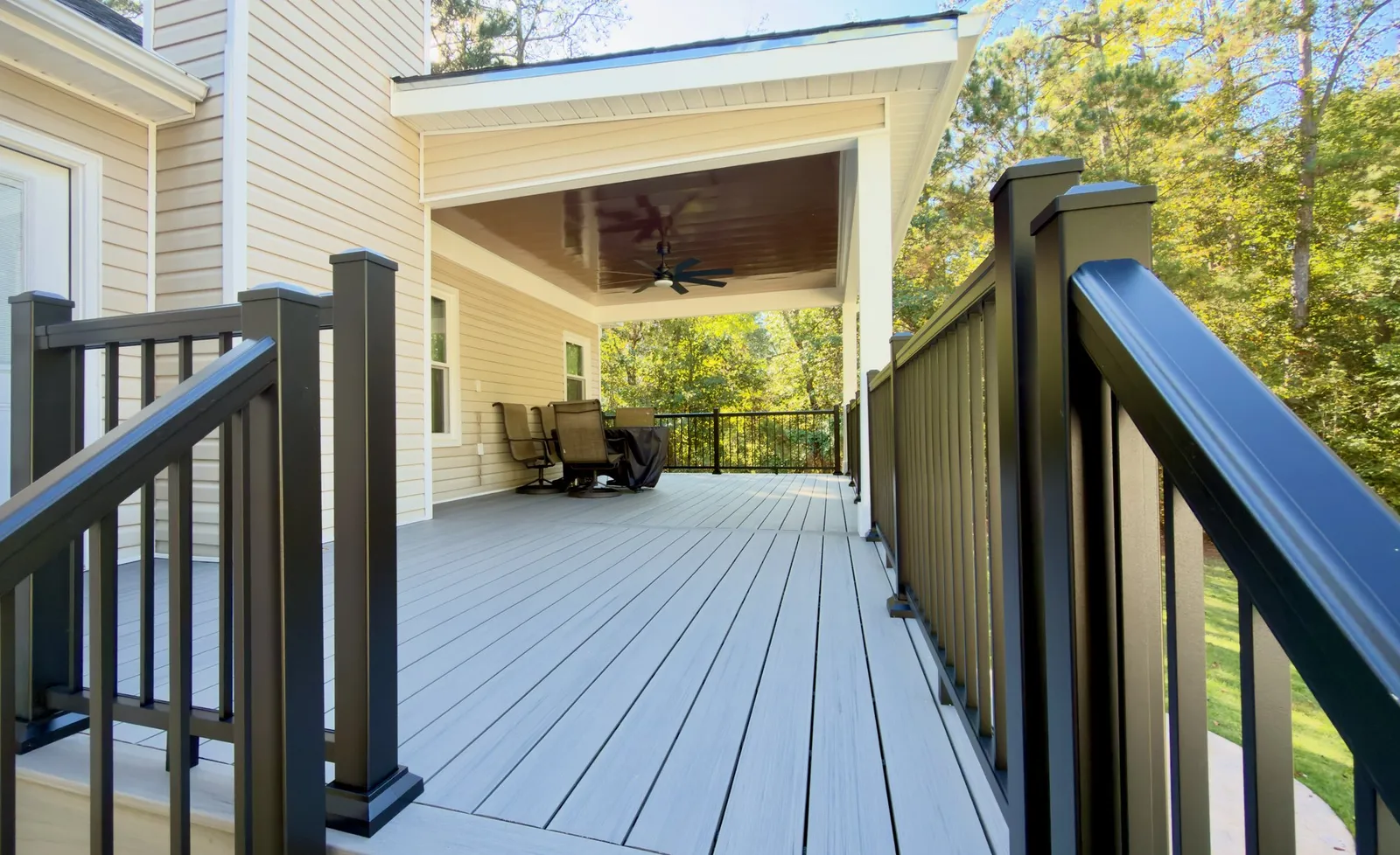 Black TimberTech aluminum rail at the top of the stairs, looking onto the covered deck