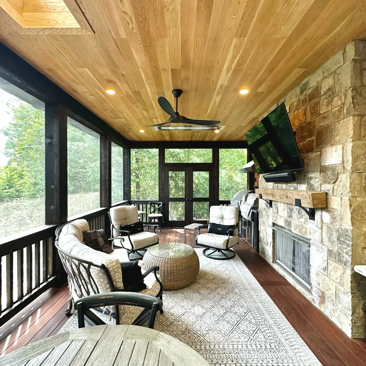 Screened porch with stacked stone fireplace and cedar plank ceiling