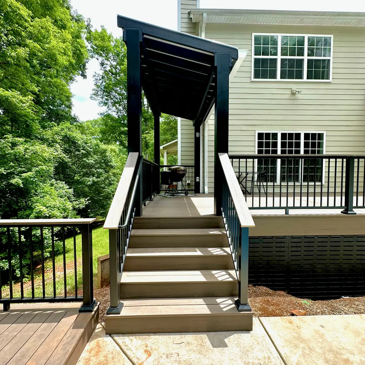 Composite deck stairs leading up to a pergola-covered landing