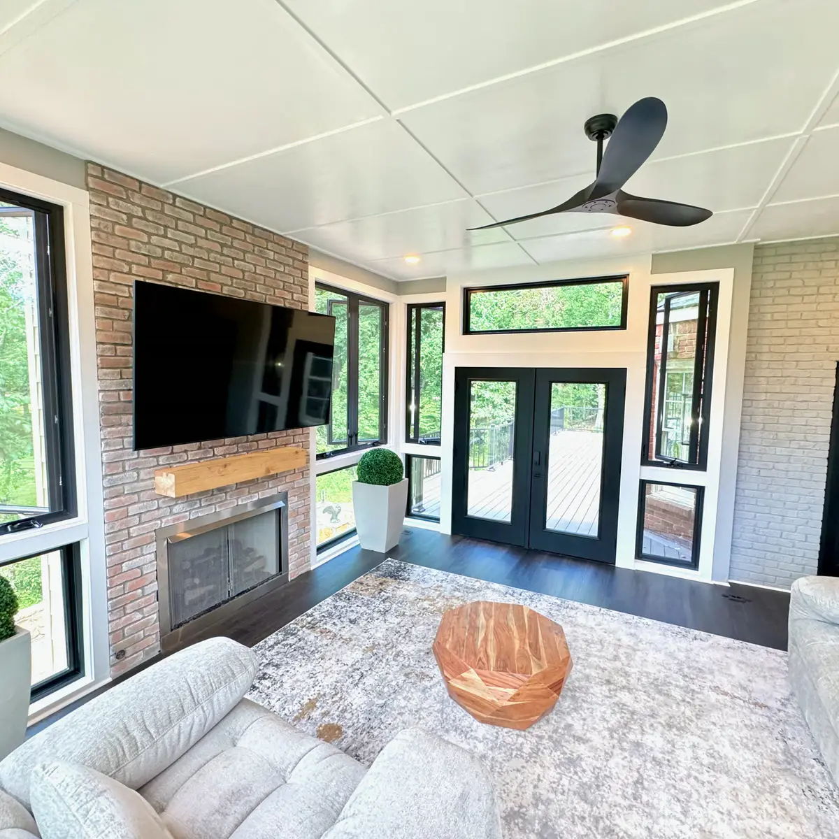 Sunroom with brick fireplace, French doors and ceiling fan