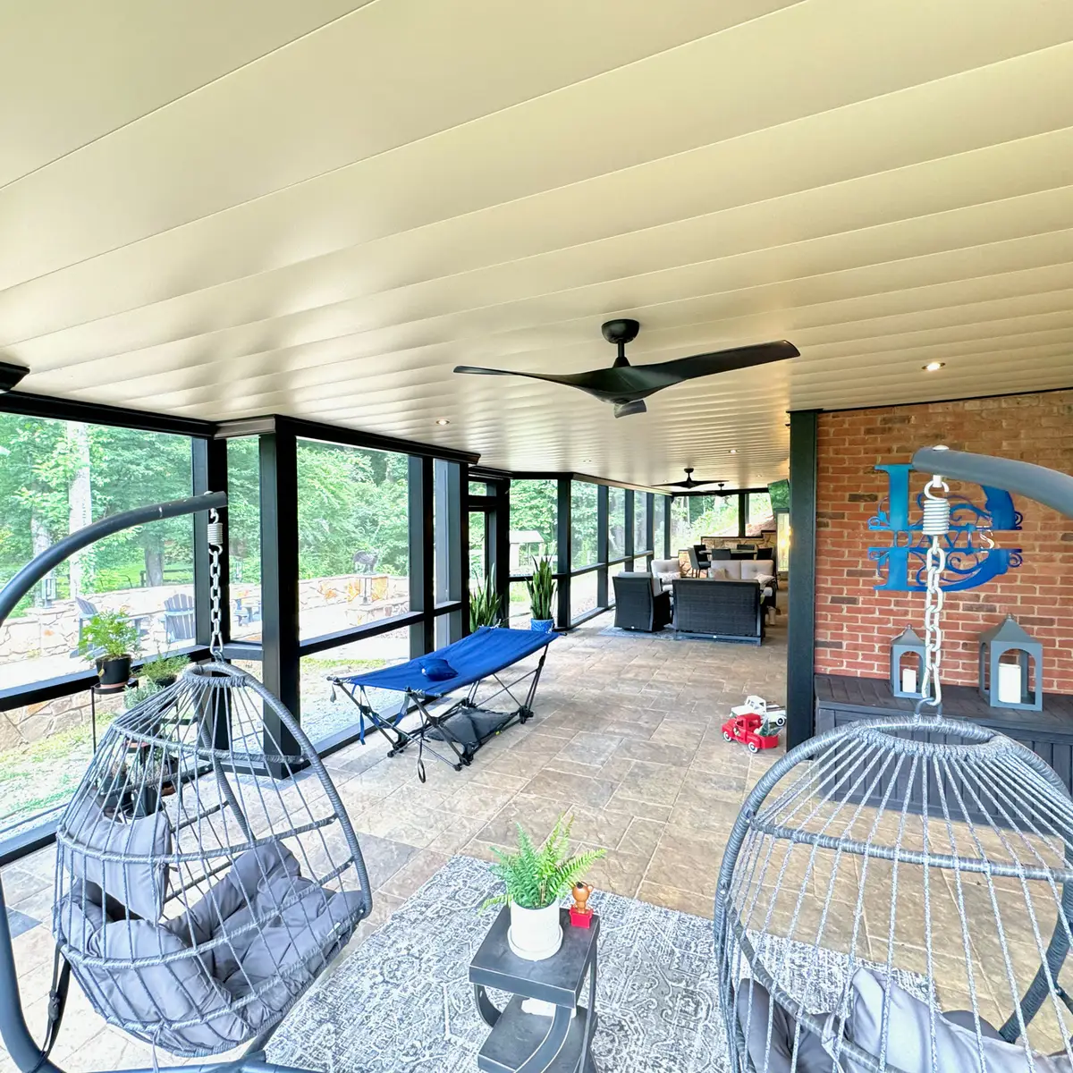 Lower-level screened patio with stone floor and ceiling fans