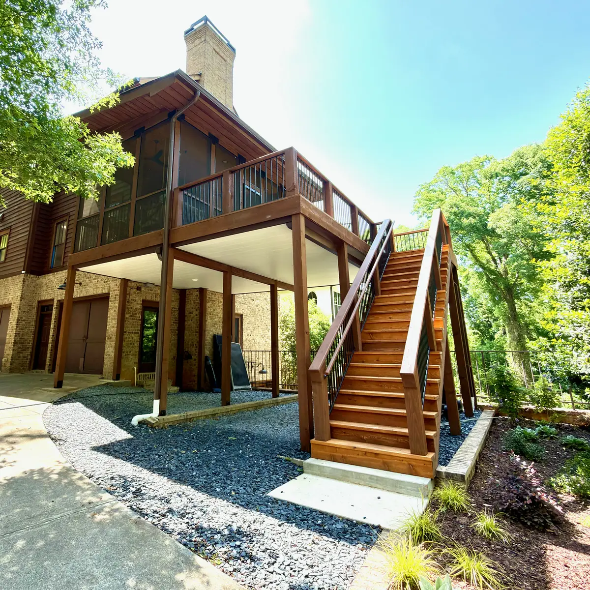Elevated screened porch and deck with long wood stairs