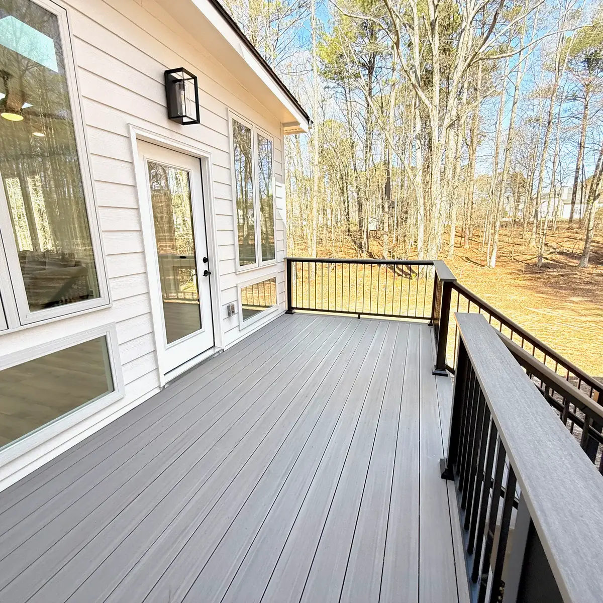 TimberTech Coastline PVC deck with black aluminum railing overlooking the wooded Fayetteville yard