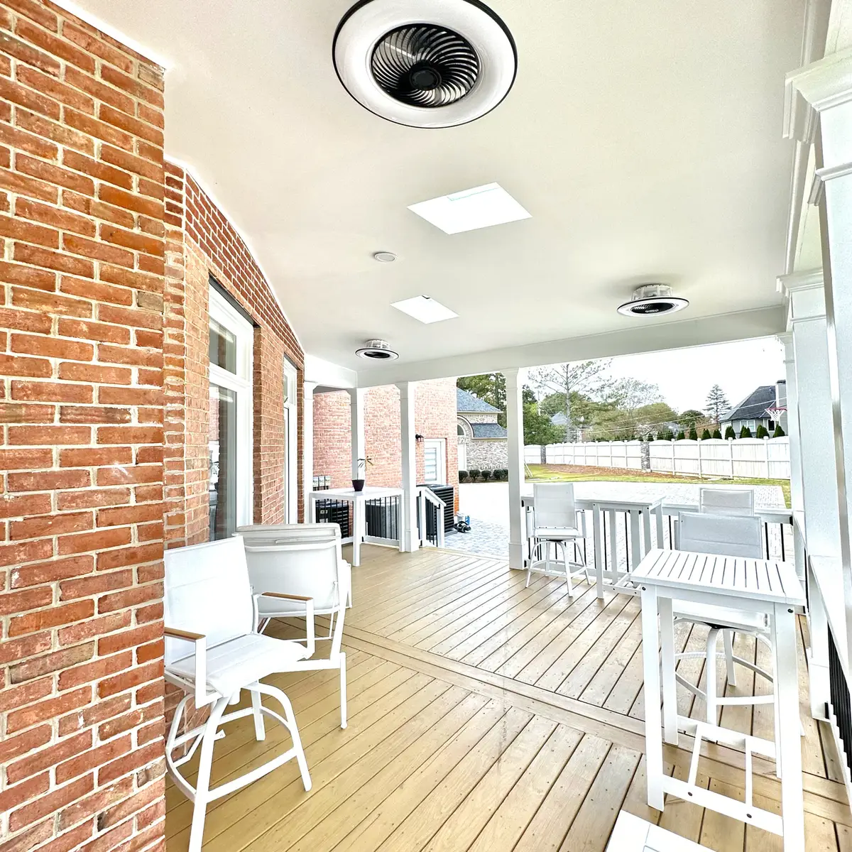 Covered porch with bar-height seating beside a brick wall