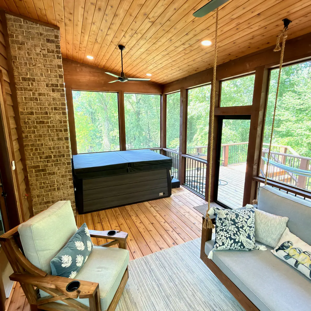 Screened porch seating with cedar ceiling and brick wall