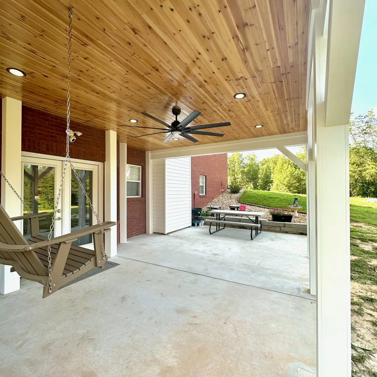 Covered porch with ceiling fan, swing and picnic table
