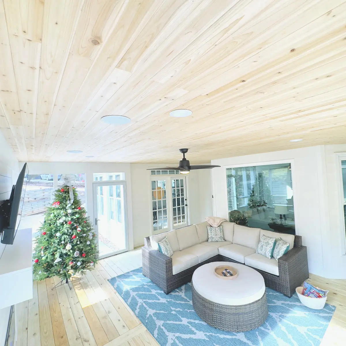 Sunroom with knotty pine ceiling, TV and wicker sectional