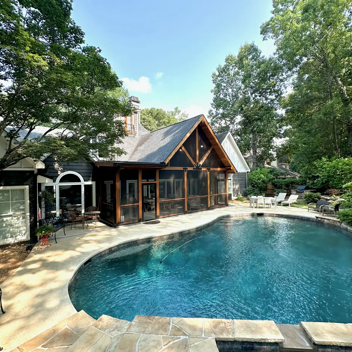 Timber screened porch addition beyond a free-form pool