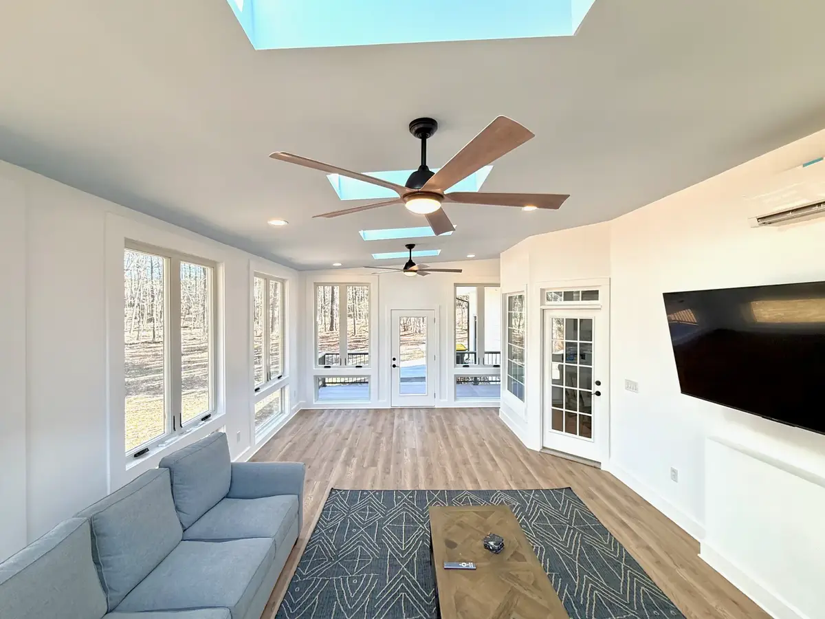 Fayetteville sunroom with skylights, ceiling fans, wall-mounted TV and floor-to-ceiling windows