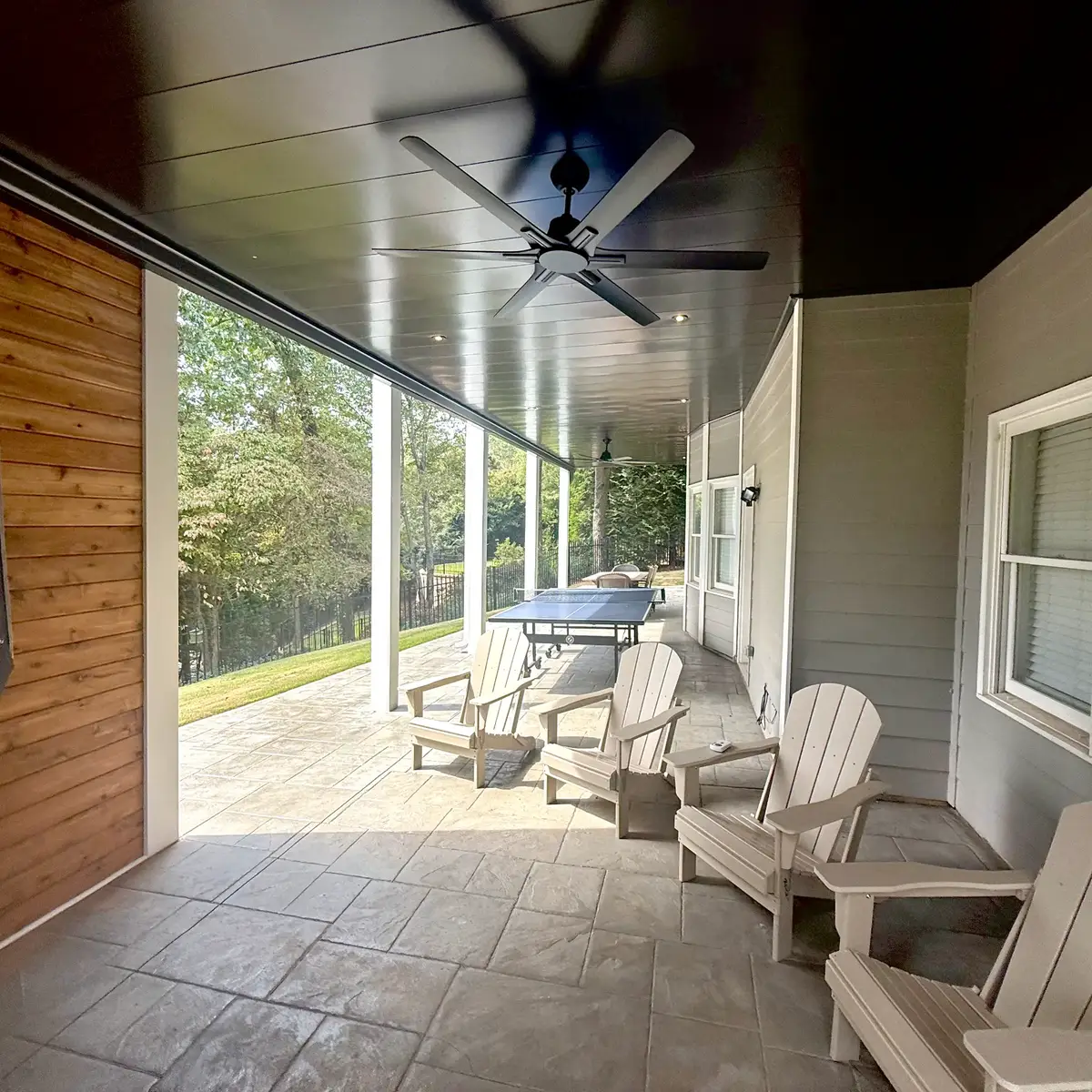 Smyrna lower patio seating beneath the black aluminum under-deck ceiling with fans and lights