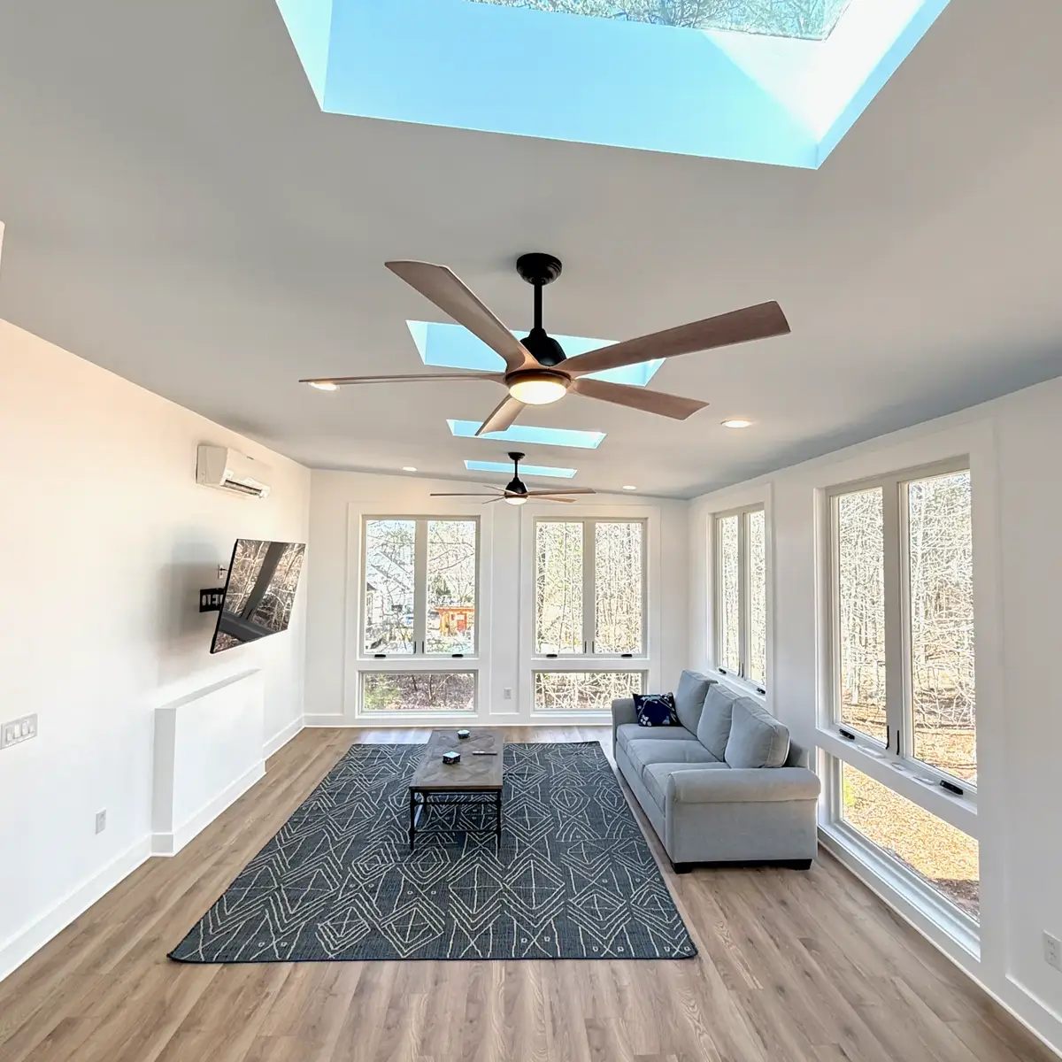 Seating area in the Fayetteville sunroom beneath skylights and a mini-split unit