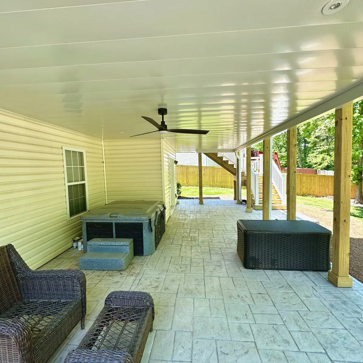 Under-deck covered patio with ceiling fan and stamped-concrete floor