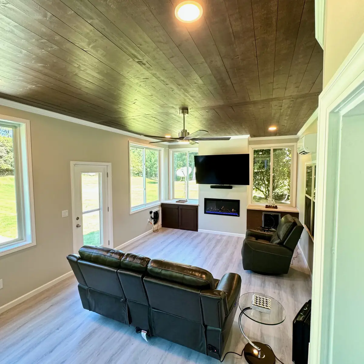 Sunroom with stained wood ceiling and media wall