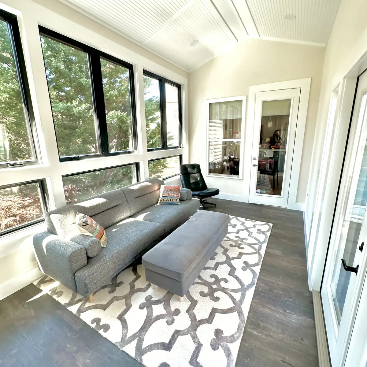 Sunroom with black-framed windows and lounge seating