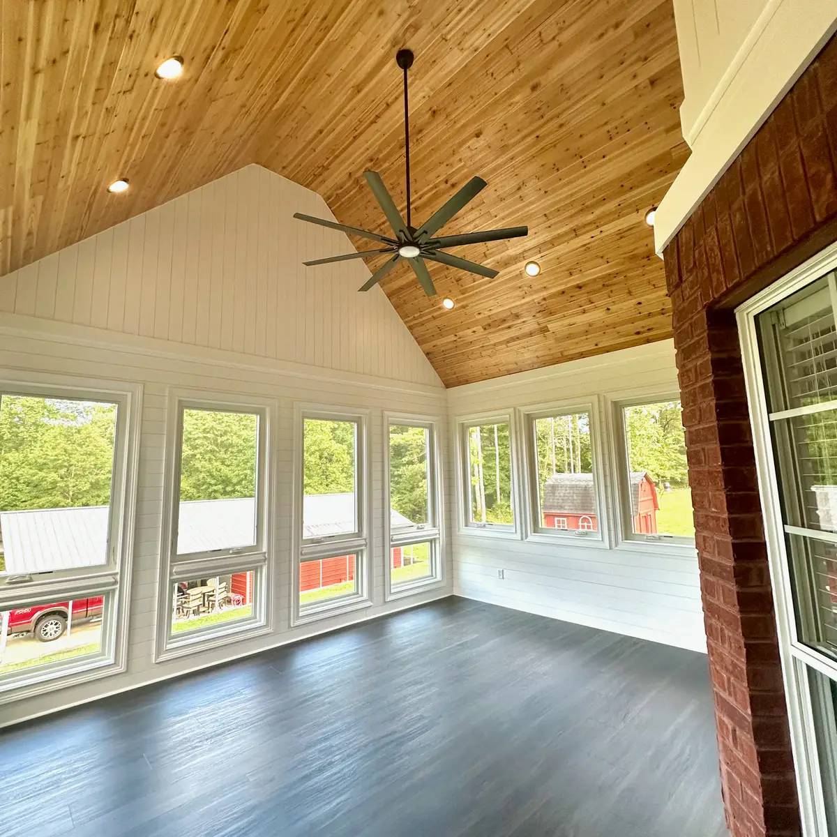 Sunroom with vaulted cedar ceiling and dark floors