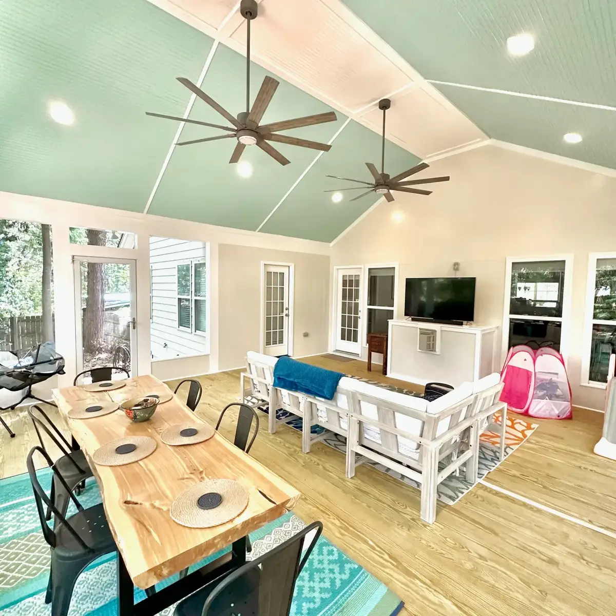 Wide view of the Atlanta screen room showing the dining table, seating area and screened walls