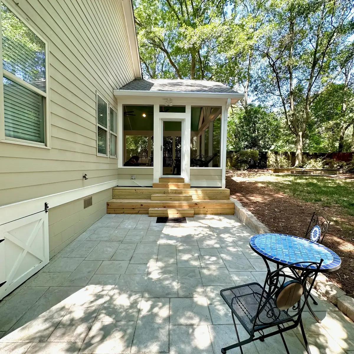 Stained concrete patio and custom pressure-treated steps leading into the Atlanta screen room