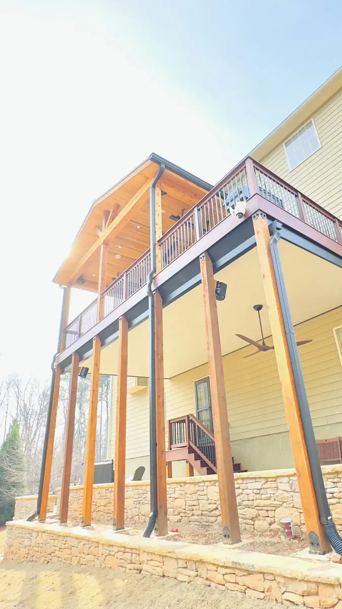 Two-story covered deck with cedar posts and stone base