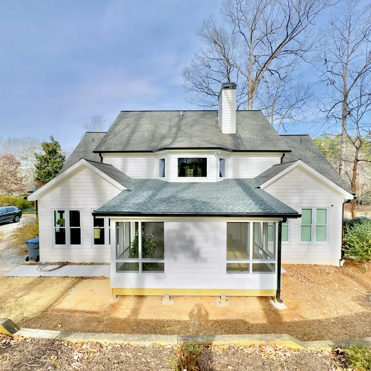 Rear sunroom addition with hip roof on a white home