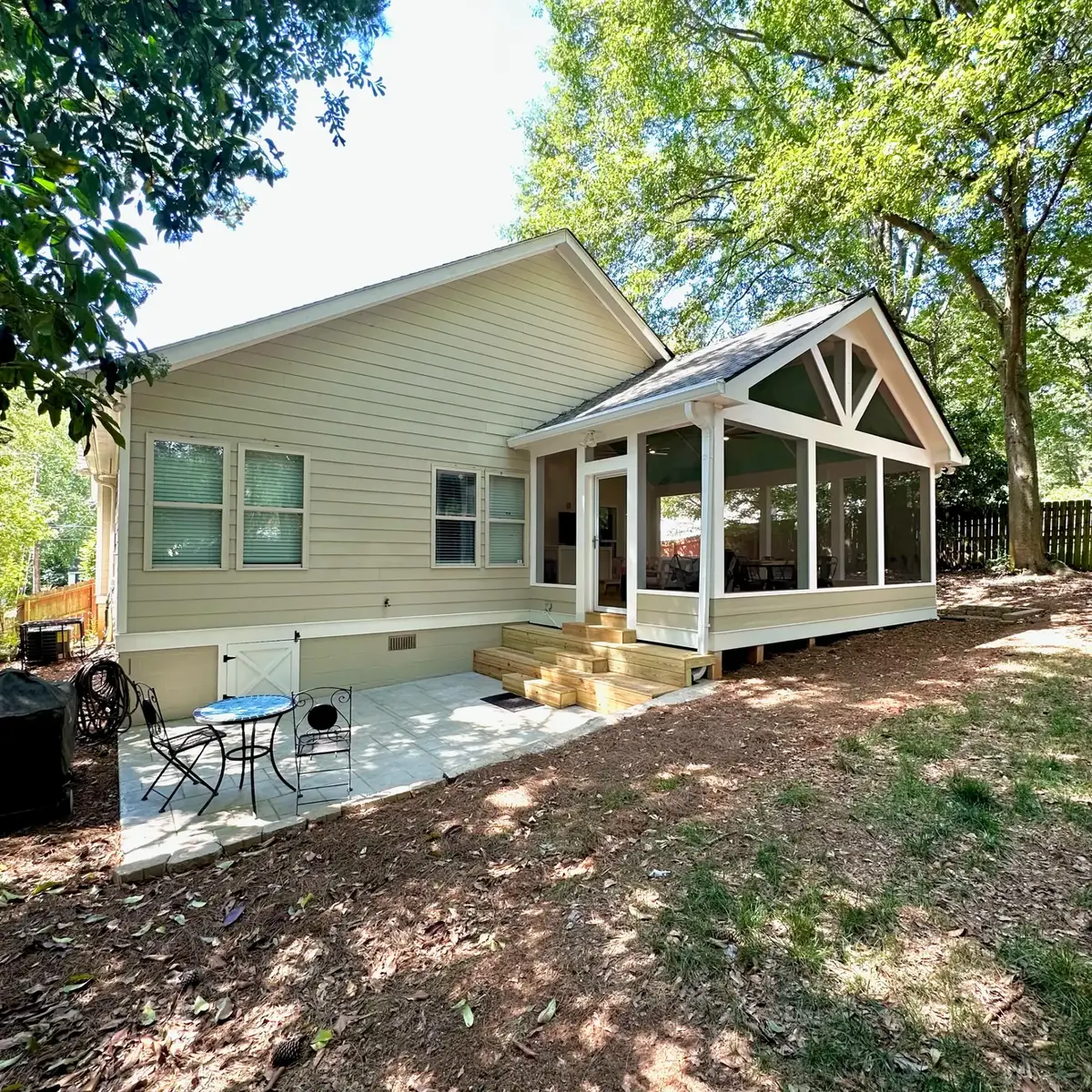 Side view of the Atlanta screened addition with bistro table on the stamped concrete patio