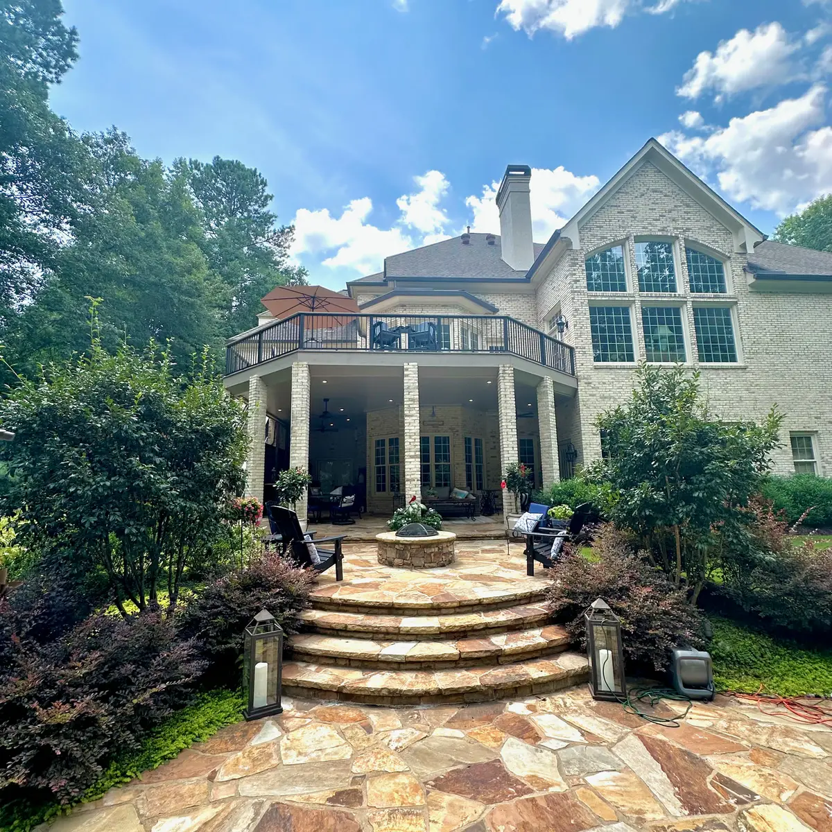 Curved upper deck over a covered flagstone patio