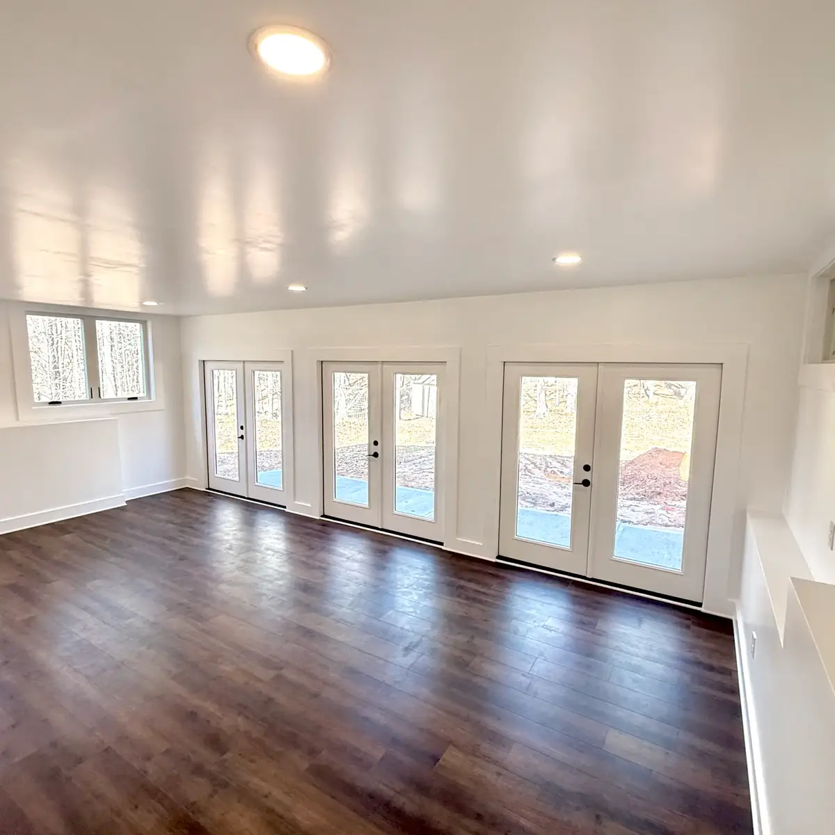 Heated and cooled Fayetteville basement extension with three sets of double doors and LVP flooring
