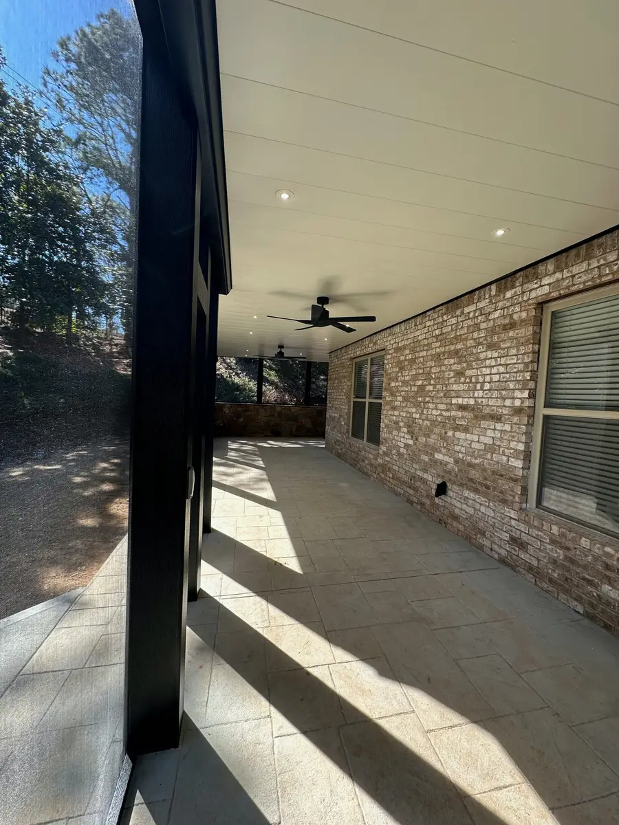 Screened patio with black framing and brick wall