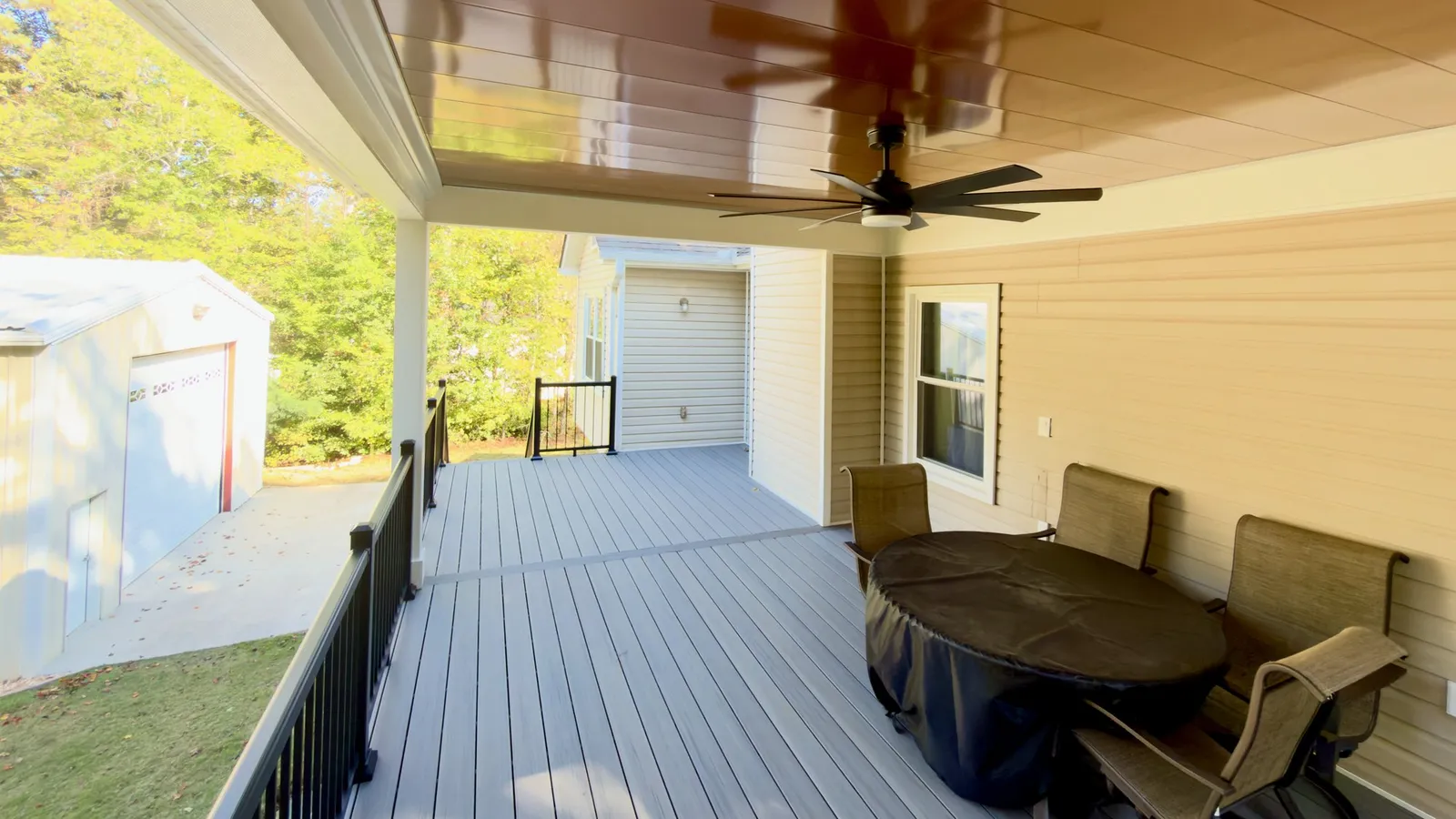 Dining table under the roof, with the composite deck running along the house