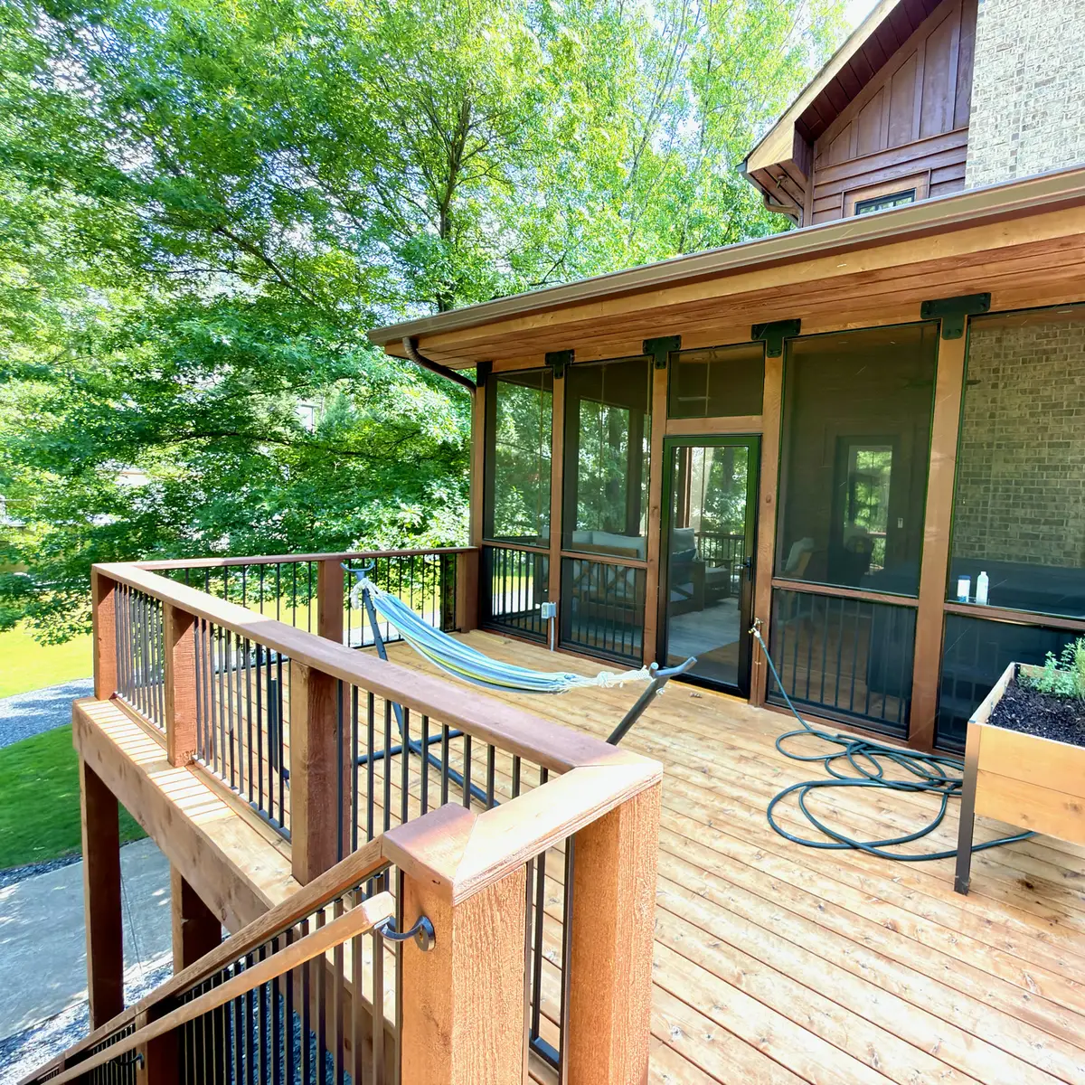 Screened porch with stained wood deck and railings