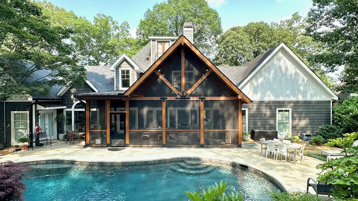 Timber-frame screened porch facing a backyard pool