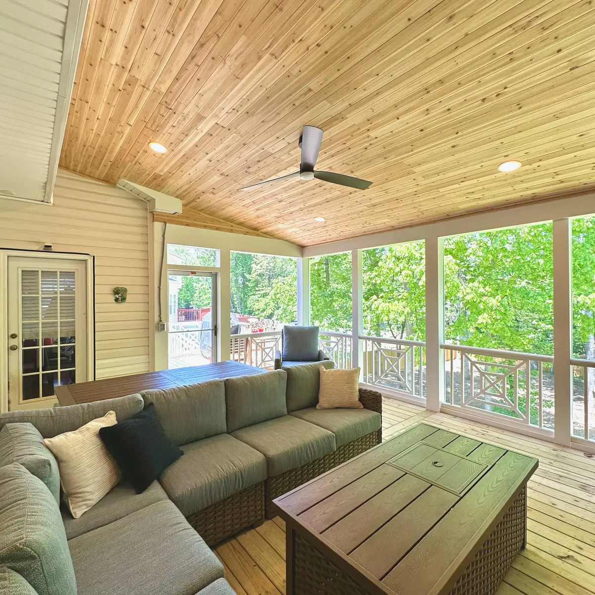 Screened porch lounge with pine ceiling, ceiling fan and sectional seating