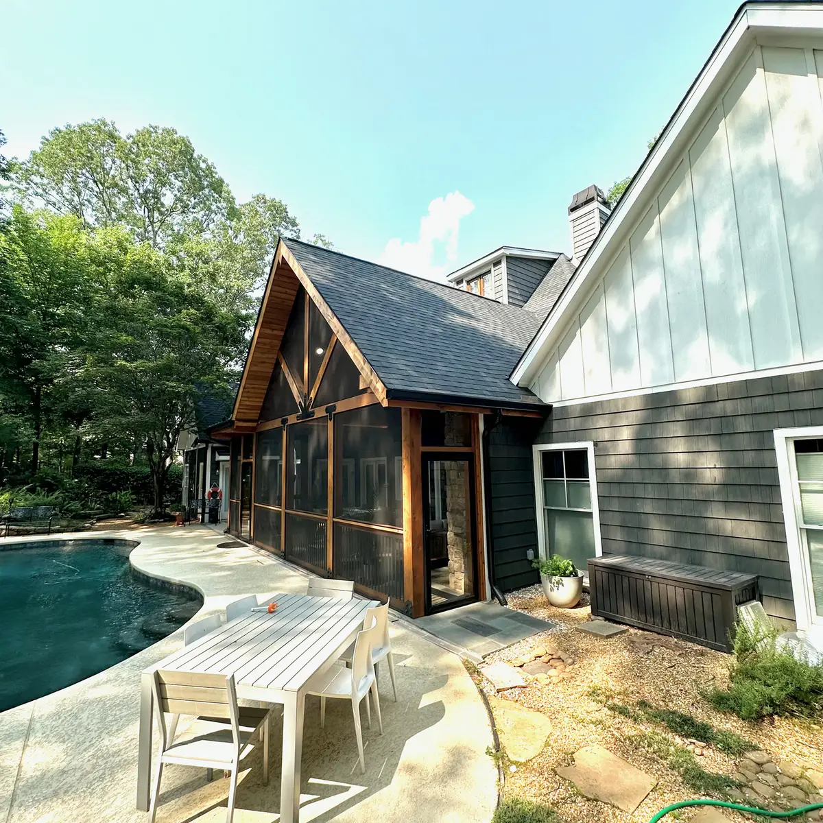 Timber-frame screened porch addition beside a pool