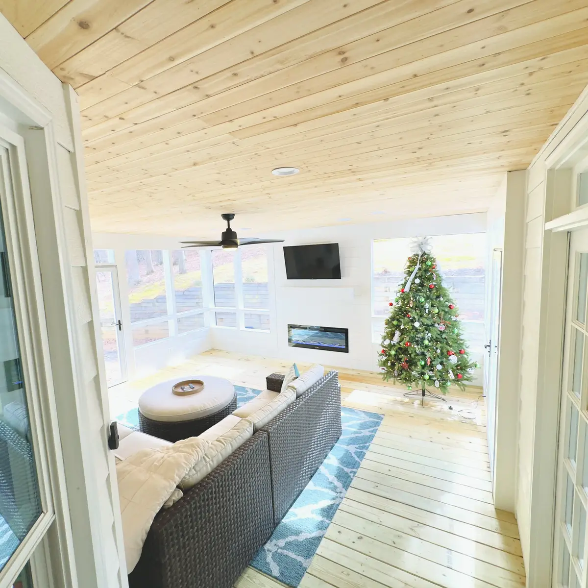 Sunroom with pine ceiling, electric fireplace and holiday tree