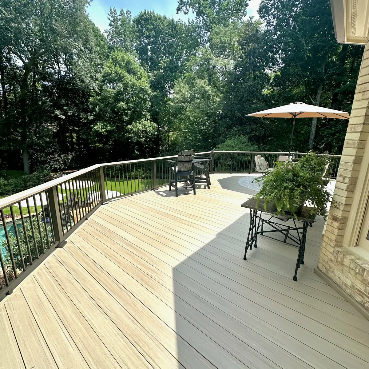 Composite deck dining area overlooking a wooded yard
