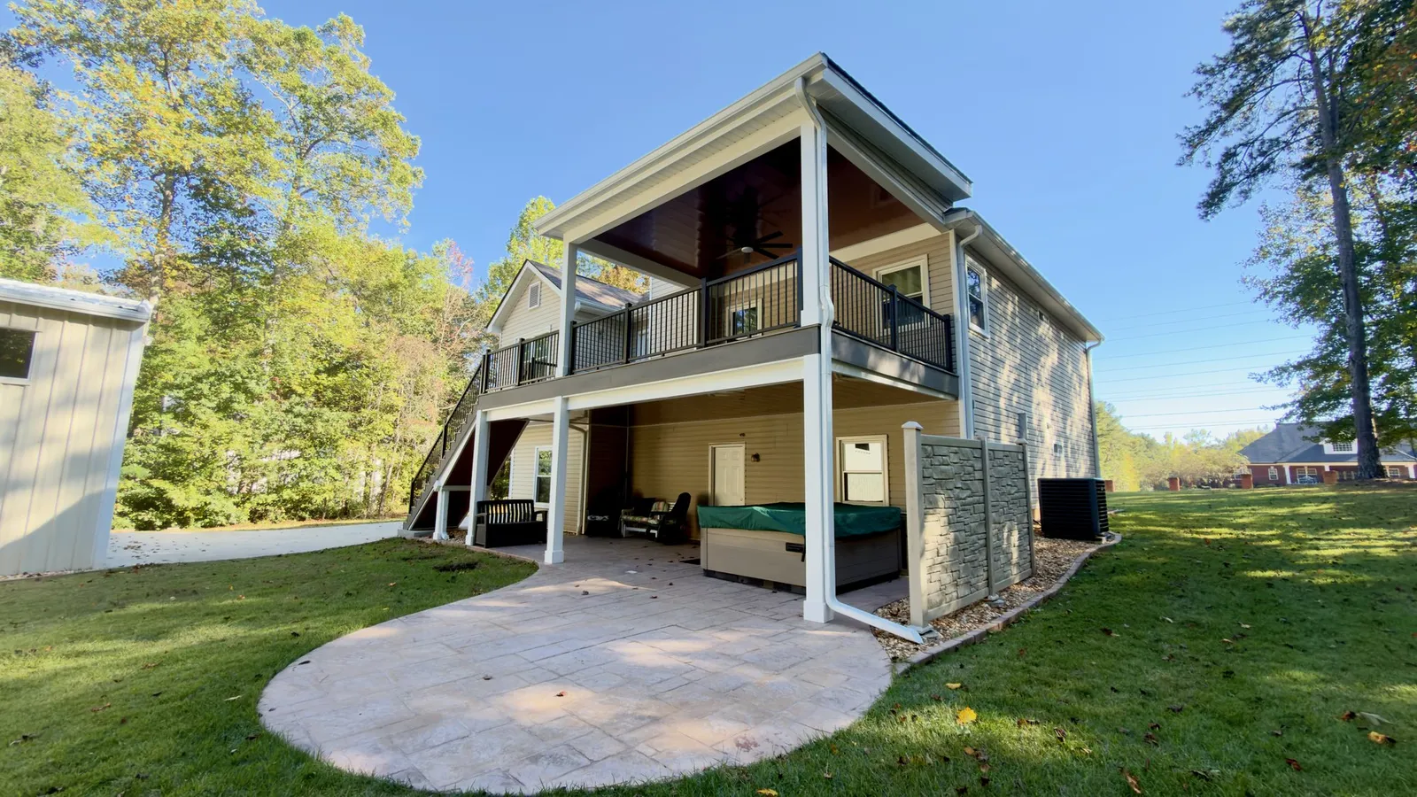 Three-quarter view of the covered deck, its white PVC-wrapped posts and the dry space beneath it